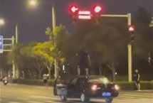 郑州一男子疑坐车顶开车还闯红灯